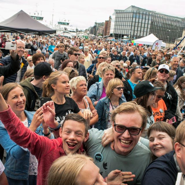 Masse publikum som smiler og ler og klapper
