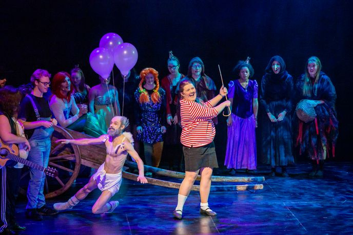 Fra oppsetning på Operaen. Det er mange mennesker med kostyme og noen med lilla ballonger på ryggen
