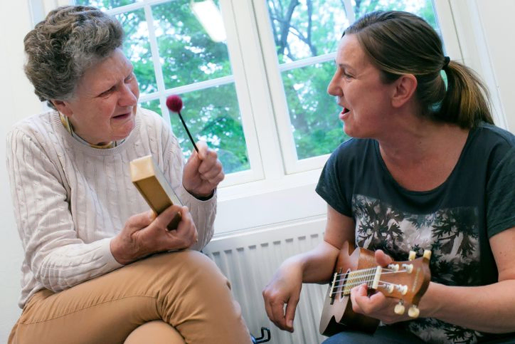 Instruktør med gitar synger sammen med elev 
